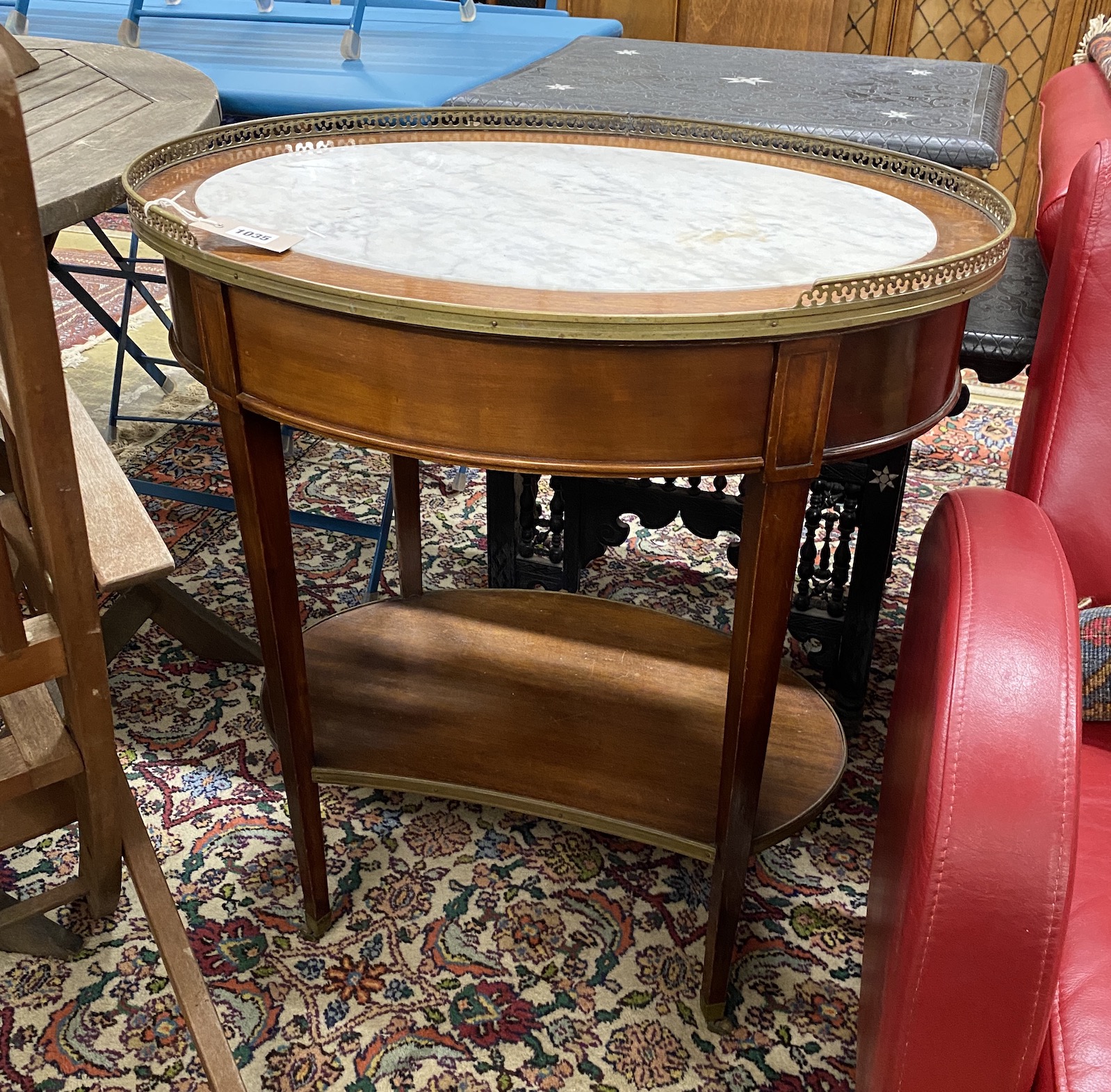 A Louis XVI style oval brass mounted marble topped two tier table, width 68cm, depth 48cm, height 74cm